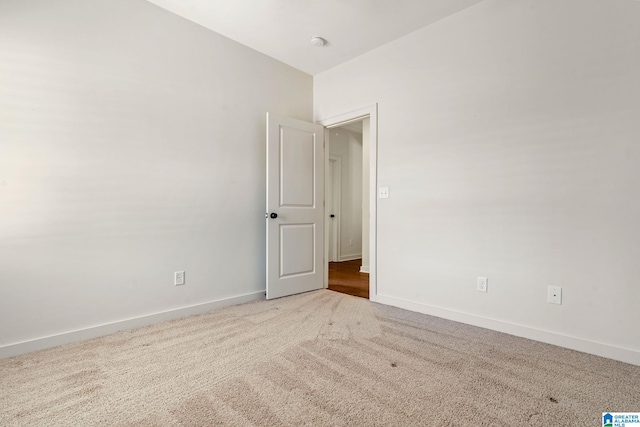 carpeted empty room with baseboards