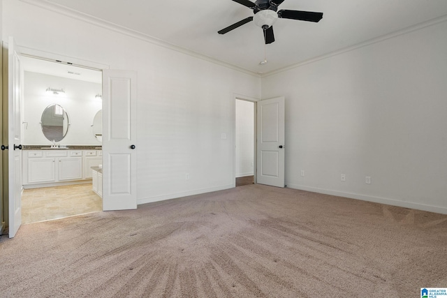 unfurnished bedroom featuring ensuite bathroom, ornamental molding, a sink, and light colored carpet