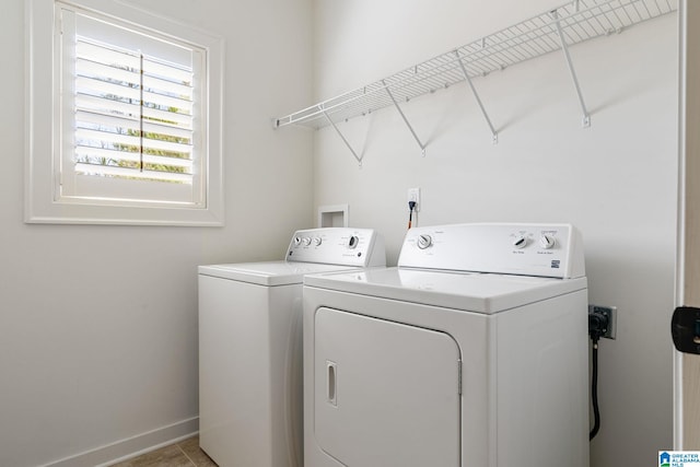 laundry area with laundry area, washer and clothes dryer, and baseboards