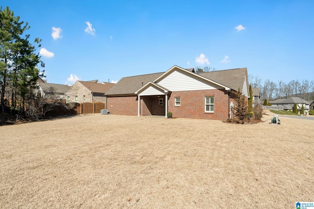 exterior space featuring a residential view, brick siding, and fence