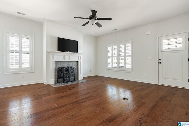 unfurnished living room with hardwood / wood-style flooring, a fireplace, visible vents, baseboards, and ornamental molding