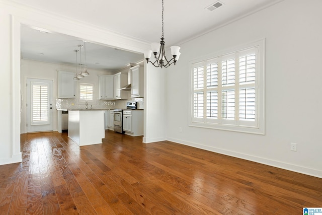 kitchen featuring electric range, visible vents, decorative backsplash, dark wood-style floors, and crown molding