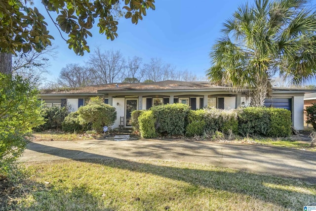 single story home featuring a front yard and concrete driveway