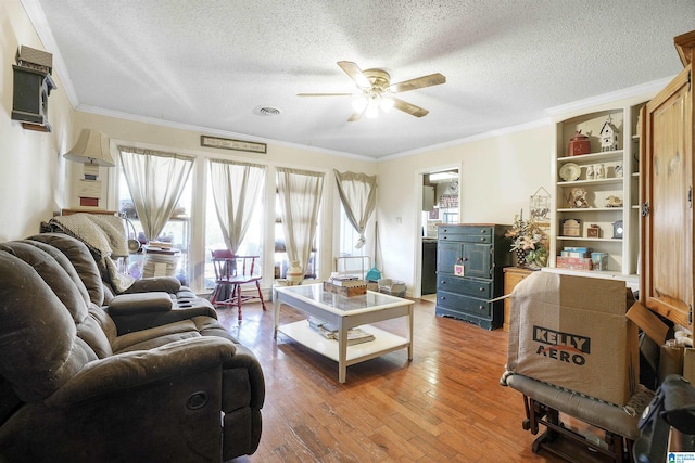 living room featuring hardwood / wood-style flooring, visible vents, and ornamental molding