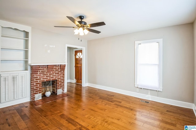 unfurnished living room featuring wood-type flooring, a fireplace, and baseboards