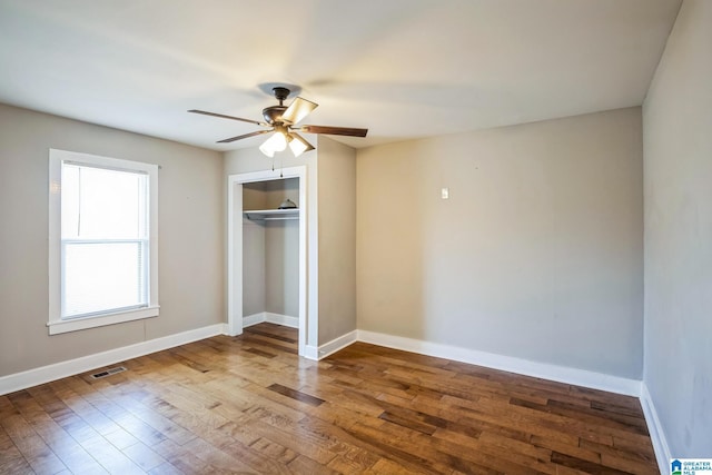 unfurnished bedroom with wood finished floors, visible vents, and baseboards