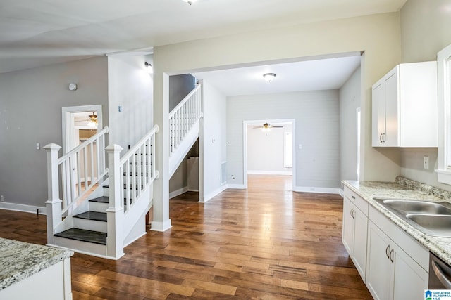 kitchen featuring baseboards, dark wood-style floors, a sink, white cabinetry, and stainless steel dishwasher