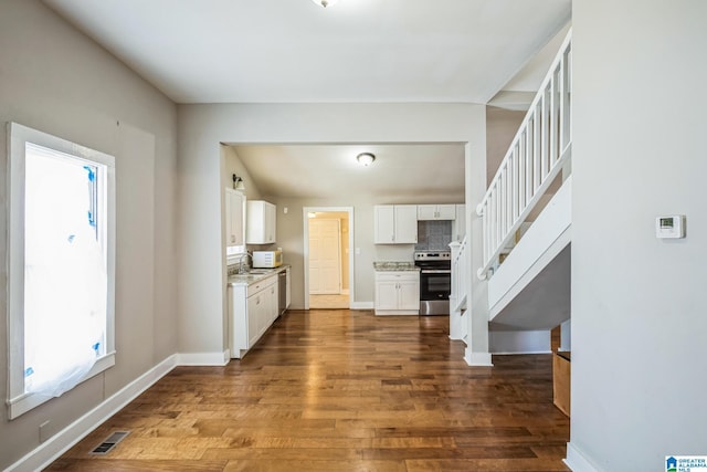 kitchen with a sink, visible vents, white cabinetry, appliances with stainless steel finishes, and dark wood-style floors