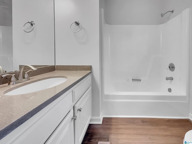 full bath featuring shower / bathtub combination, wood finished floors, and vanity