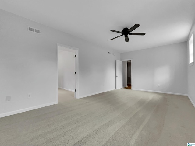 unfurnished room featuring carpet floors, baseboards, visible vents, and a ceiling fan