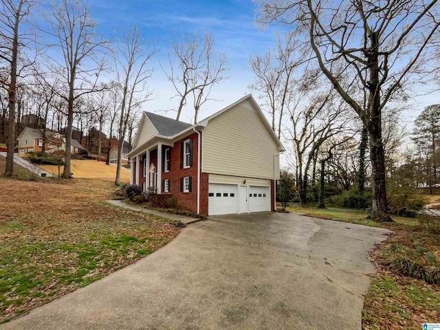 view of home's exterior featuring a garage, concrete driveway, and brick siding