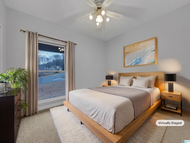 bedroom featuring light carpet and a ceiling fan