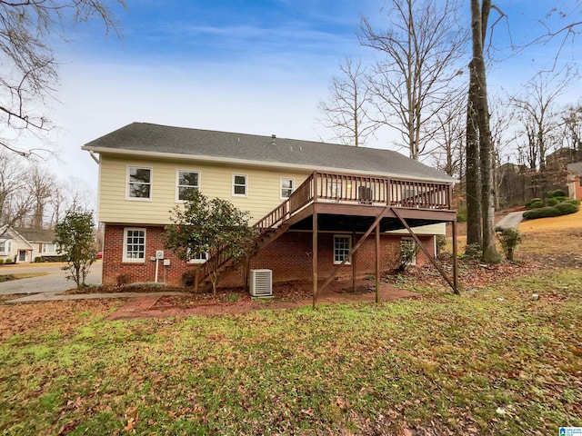 back of property with stairway, a deck, central AC, and brick siding