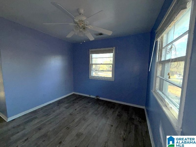 unfurnished room with baseboards, visible vents, ceiling fan, and dark wood-style flooring