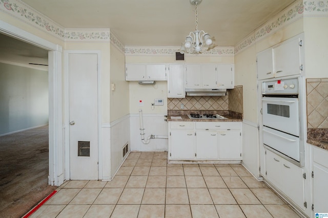 kitchen featuring a warming drawer, white appliances, and white cabinets