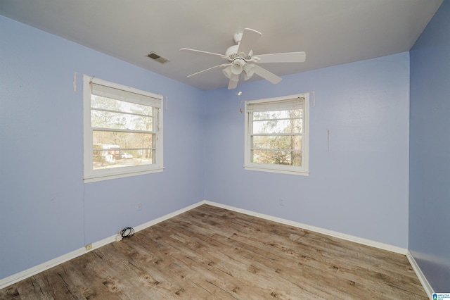 unfurnished room featuring baseboards, visible vents, ceiling fan, and light wood finished floors