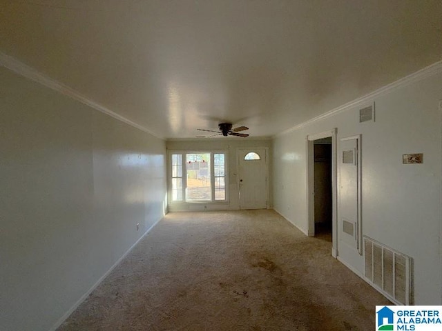 unfurnished room featuring light carpet, a ceiling fan, visible vents, and crown molding