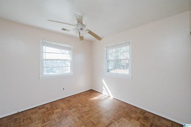 unfurnished room featuring baseboards, a ceiling fan, visible vents, and a healthy amount of sunlight