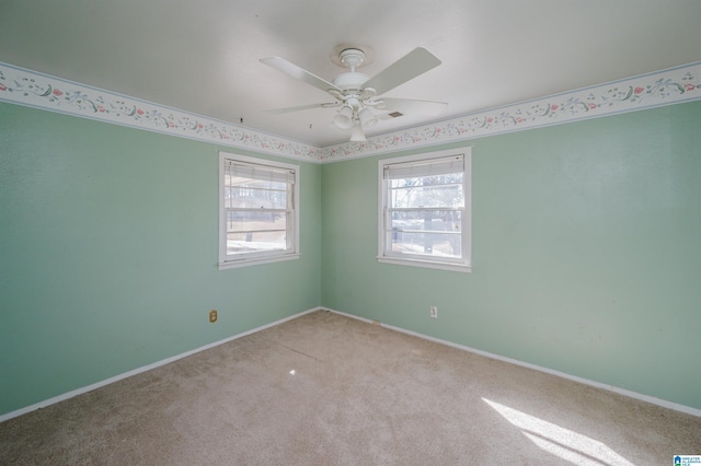 spare room featuring ceiling fan, baseboards, and light colored carpet