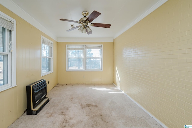 spare room featuring ornamental molding, heating unit, light colored carpet, and brick wall