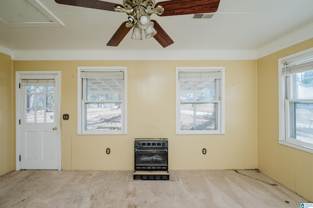 entrance foyer with visible vents, ceiling fan, ornamental molding, heating unit, and carpet floors