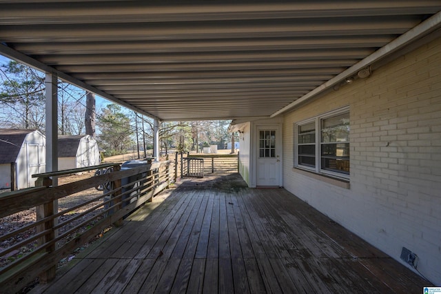 wooden deck featuring a shed and an outdoor structure