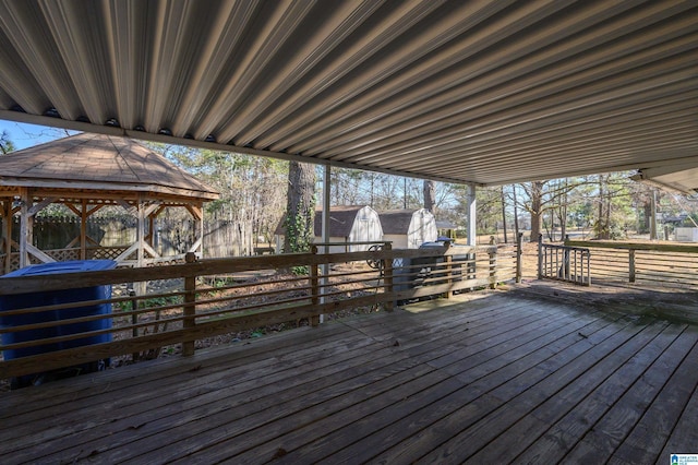 wooden deck with an outbuilding, a gazebo, and a storage unit