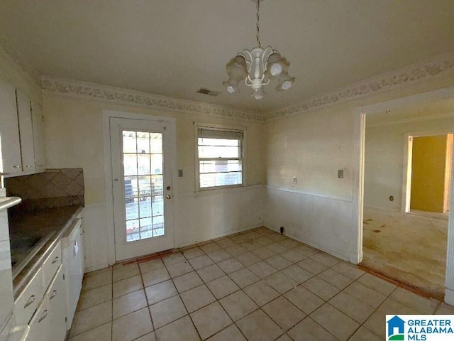 unfurnished dining area with a chandelier, light tile patterned flooring, and visible vents