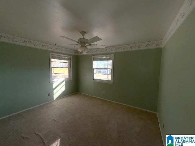 carpeted empty room featuring ceiling fan and baseboards