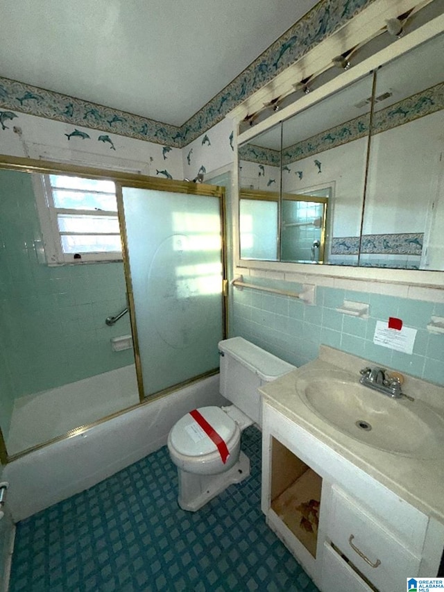 full bath featuring toilet, enclosed tub / shower combo, tile patterned floors, vanity, and tile walls