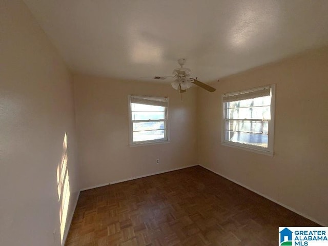 spare room featuring a ceiling fan and a wealth of natural light