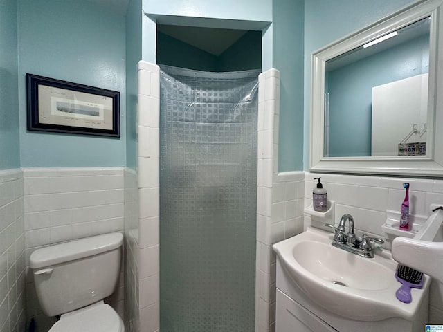 bathroom featuring toilet, a shower stall, and wainscoting