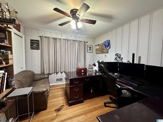 home office with light wood finished floors, ceiling fan, and visible vents