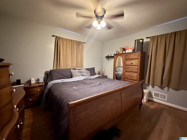 bedroom featuring visible vents, ceiling fan, baseboards, and dark wood-style floors
