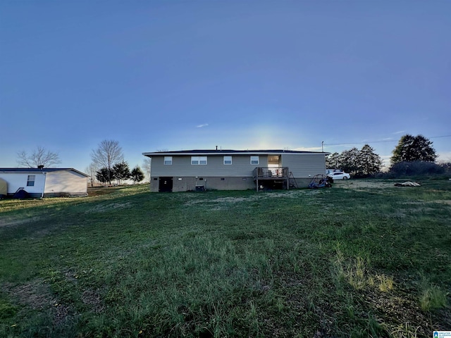 rear view of property featuring a yard and crawl space