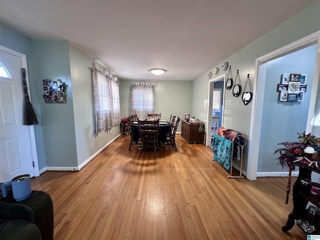 dining room featuring baseboards and light wood-type flooring