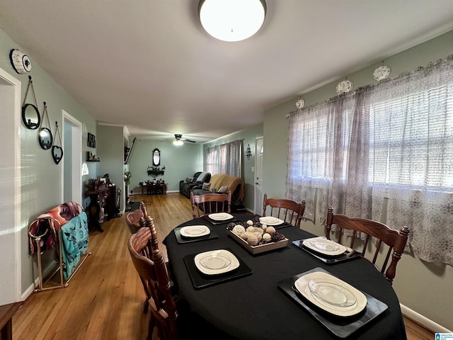 dining room featuring baseboards, a ceiling fan, and wood finished floors