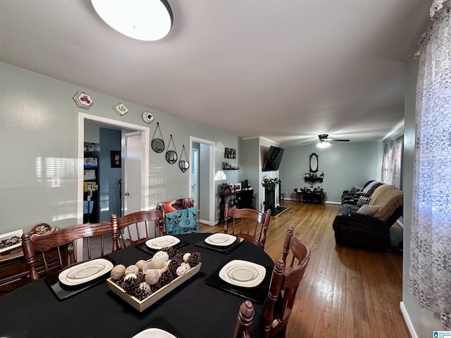 dining room featuring hardwood / wood-style floors, baseboards, and a ceiling fan
