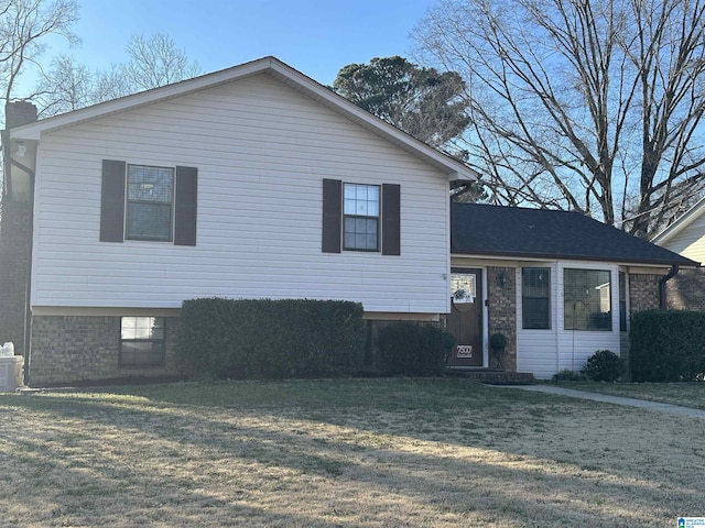 split level home with a front yard and brick siding