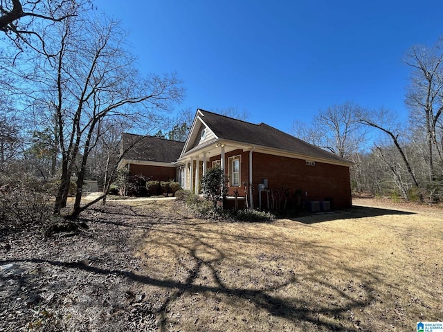 view of home's exterior with cooling unit and brick siding