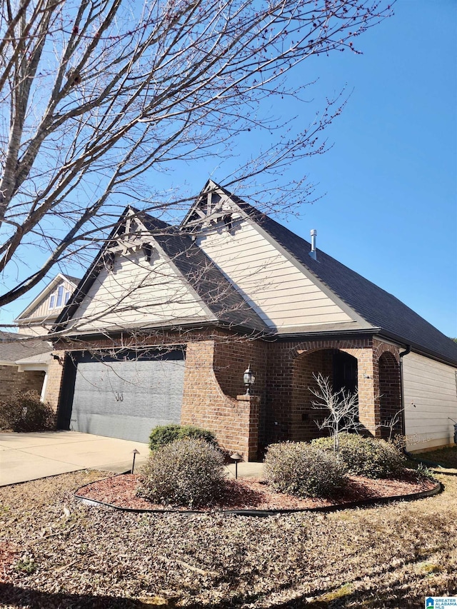 view of front of house with a garage, concrete driveway, and brick siding