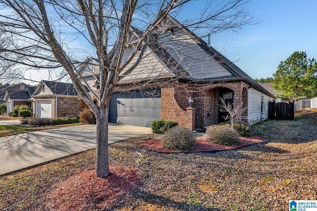 view of side of property featuring brick siding, driveway, and fence