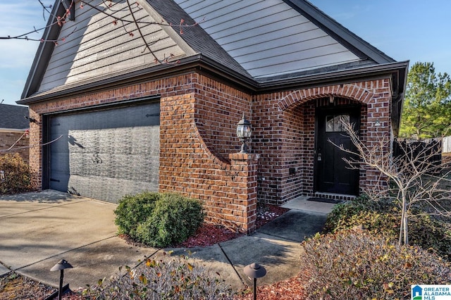 property entrance featuring brick siding, driveway, and roof with shingles