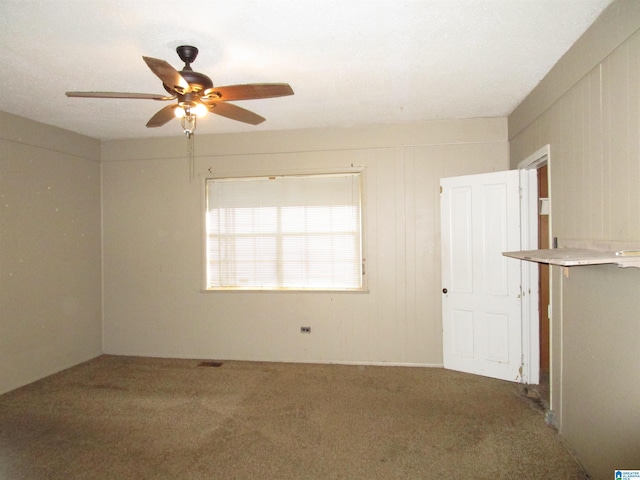 carpeted empty room featuring a ceiling fan