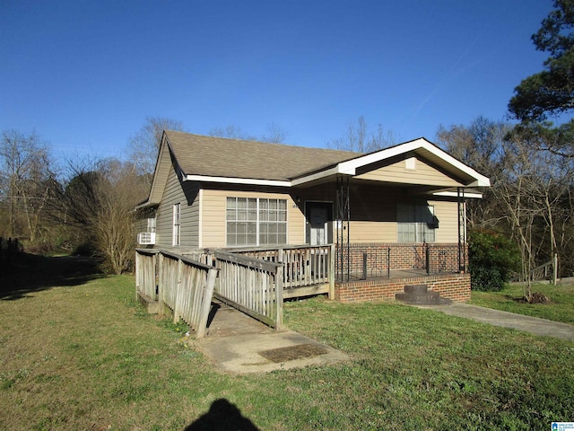 view of front facade featuring brick siding, a shingled roof, and a front yard