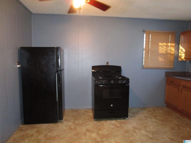 kitchen with dark countertops, brown cabinets, ceiling fan, and black appliances