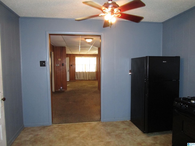 kitchen with a ceiling fan, wood walls, and black appliances