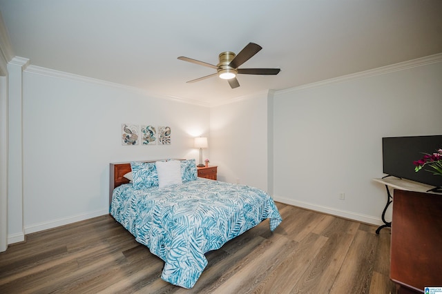 bedroom featuring baseboards, wood finished floors, and crown molding