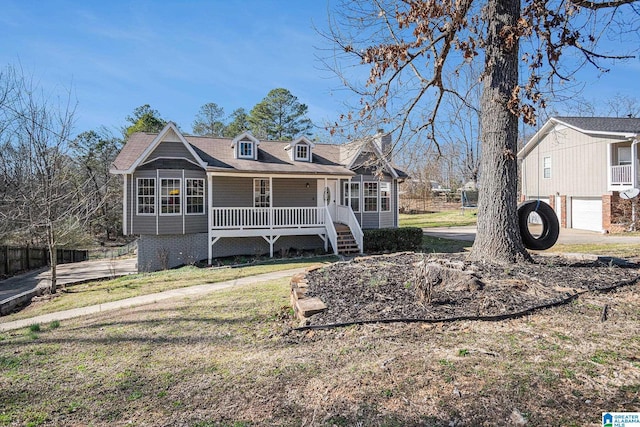 view of front of home with covered porch, driveway, an attached garage, and a front yard