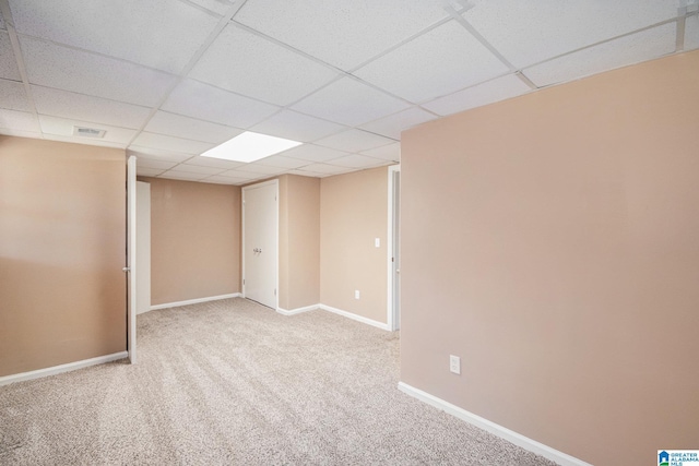 unfurnished room featuring visible vents, baseboards, a drop ceiling, and carpet flooring